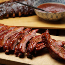 Load image into Gallery viewer, Our pork Baby Back ribs are marinated in apple juice, rubbed with secret spices and slow-smoked over real hickory. Fully cooked. Ready to thaw, and heat in the oven or on the grill.