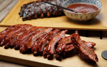 Load image into Gallery viewer, Our pork Baby Back ribs are marinated in apple juice, rubbed with secret spices and slow-smoked over real hickory. Fully cooked and ready to thaw, and heat and eat!
