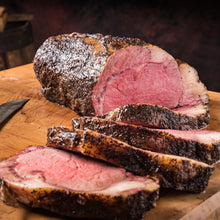 Load image into Gallery viewer, Our Certified Angus Beef® Prime Rib is rubbed with our flavorful seasonings and slow-smoked over hickory for hours. This is a delicious traditional favorite for any holiday meal. Fully cooked to medium rare. Simply thaw, heat, and eat.
