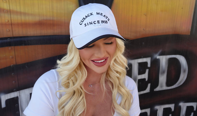 Taylor Cusack wearing the white Cusack Meats cap with black writing
